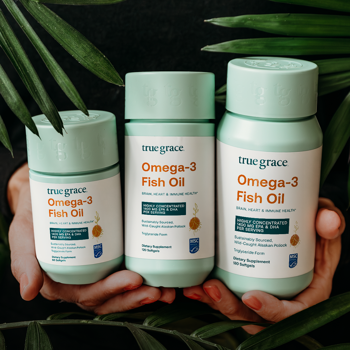 Omega-3 fish oil supplement bottles, mint and white labels, in hand