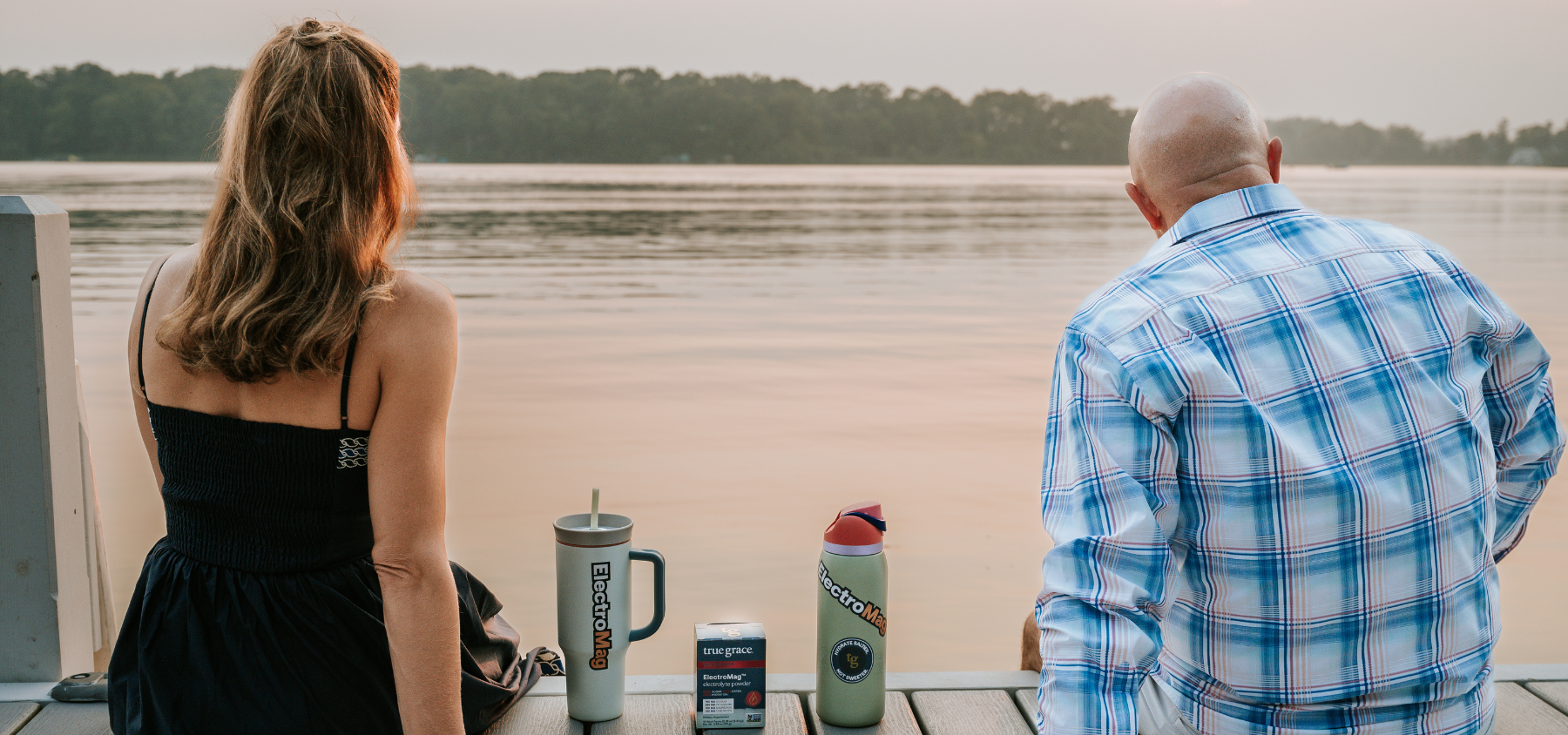 Husband and wife, Kristie and Brian Hall sitting on their family lake house's dock