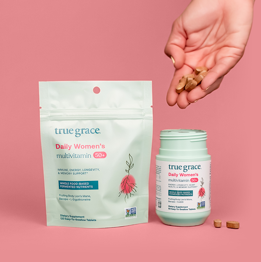True Grace Daily Women's Multivitamin packet and bottle on a pink background