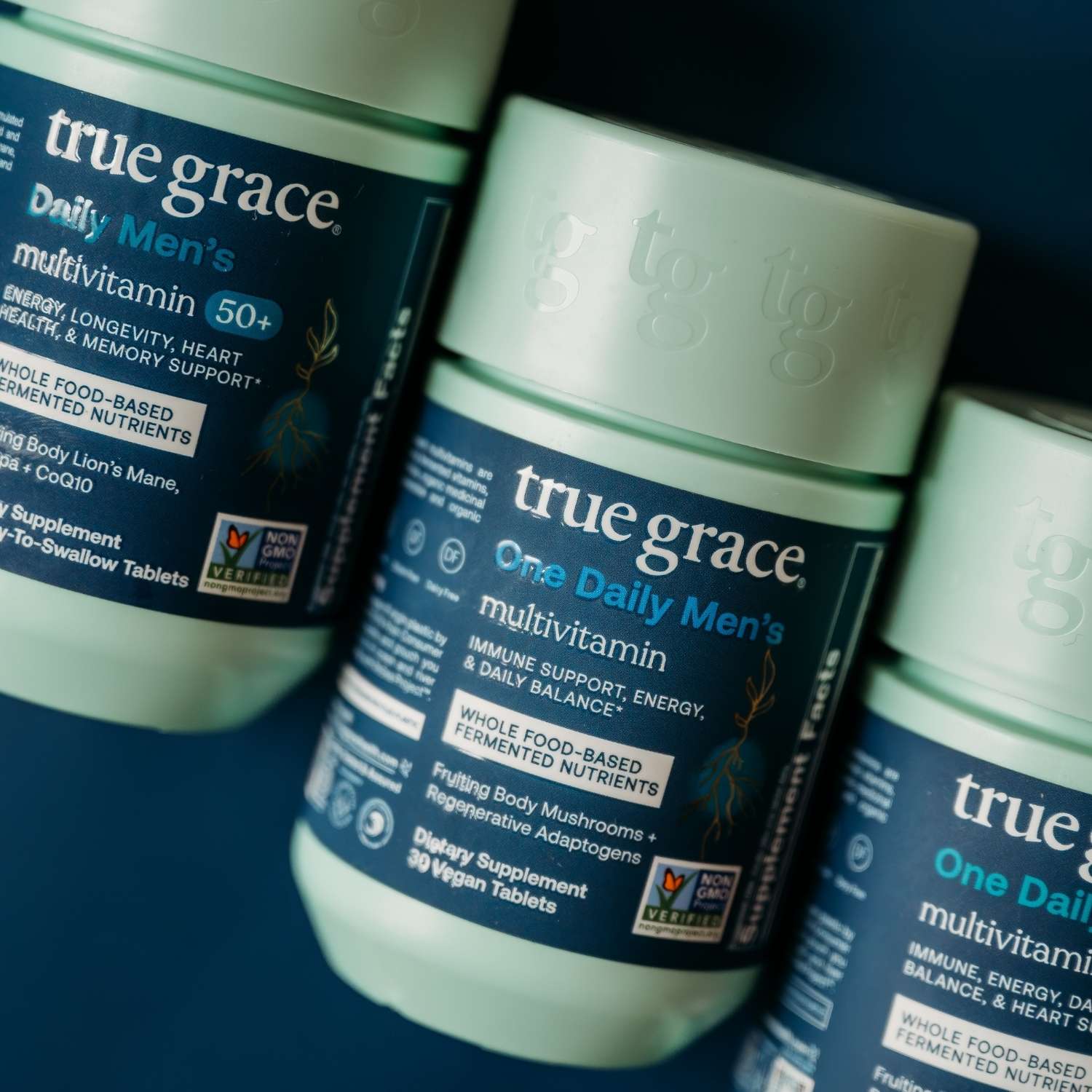 True Grace One Daily Men's multivitamin bottles on a blue background