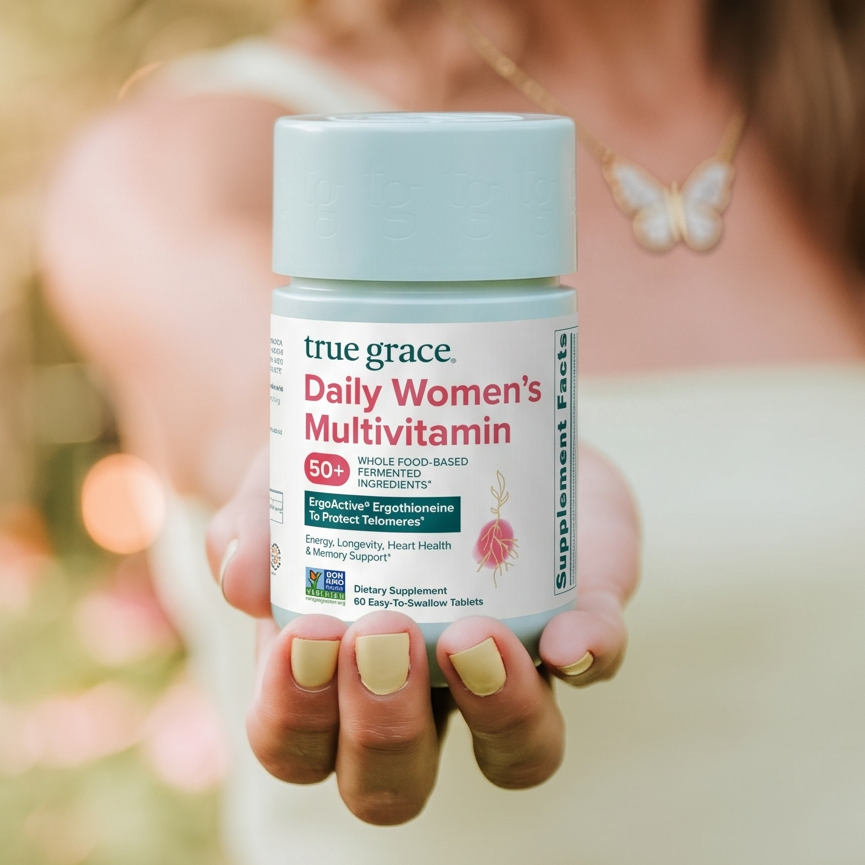 A woman holding out a bottle of Daily Women's 50+ Multivitamin in her palm