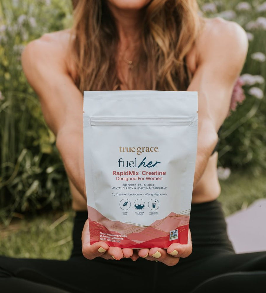 A woman holding out a pouch of FuelHer RapidMix Creatine