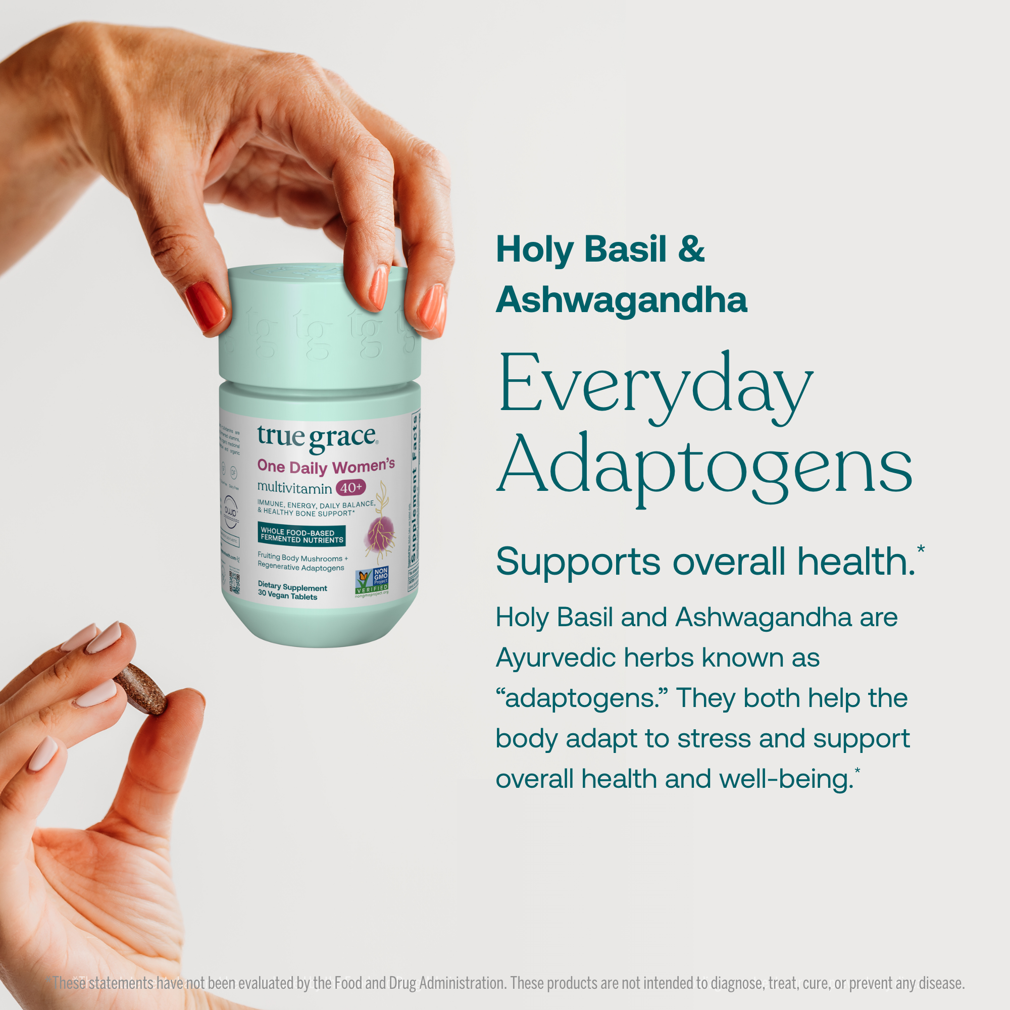 Hand holding True Grace One Daily Women's 40+ Multivitamin supplement container with text about Holy Basil, Ashwagandha, and True Grace adaptogens.